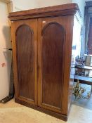 A Victorian mahogany double wardrobe with caddy and cavetto cornice over twin arched panel doors