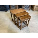 A 1930's 40's oak set of three nesting tables on turned supports, largest measures 46cm x 34cm x