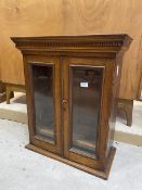 A 19thc mahogany tabletop display cabinet of small proportions, the dental cornice over two glazed