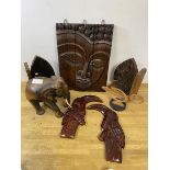 A quantity of carvings including a south east Asian sectional wall panel depicting woman's face,