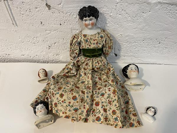 A Victorian china head doll, press marked verso 4, with enameled face, china arms (one finger a/f