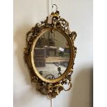 A 19thc giltwood and composition girandolle mirror, the oval plate within a conforming frame