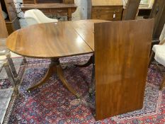 A reproduction Regency style twin pedestal mahogany dining table, the tablet shaped top with