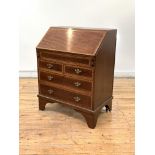 An Edwardian mahogany bureau of small proportions, the satinwood cross banded fall front revealing