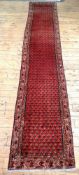 A hand knotted Persian Seraband design runner rug, the red field with boteh motif and bordered 400cm