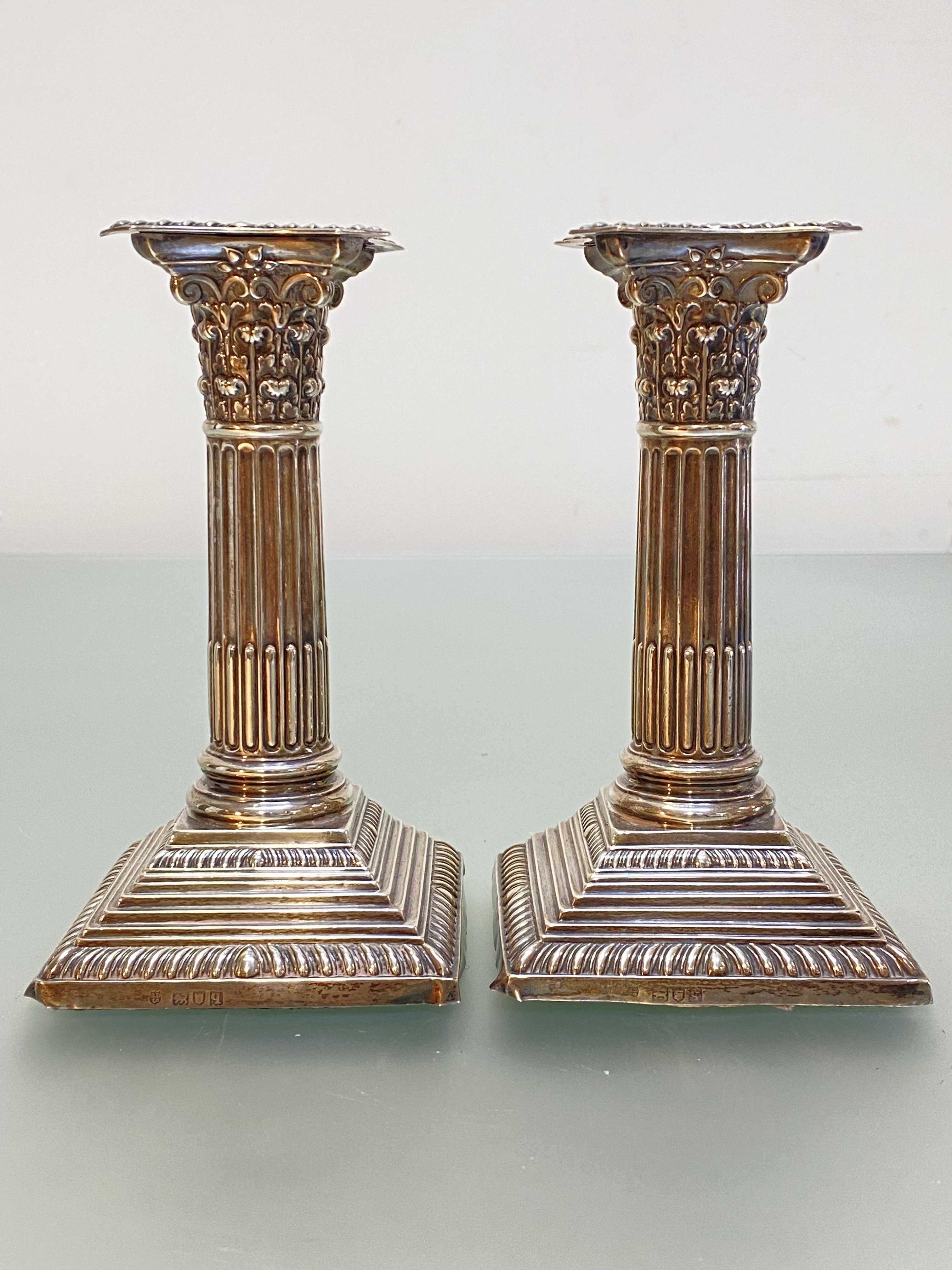 A pair of George V silver dwarf candlesticks, Stewart Dawson & Co., London 1911, of Corinthian