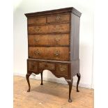 An 18th century and later walnut chest on stand, the projecting cornice over two short and three