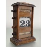 An oak perpetual desk calendar, c. 1930. Height 24cm