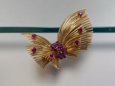 A ruby-set 18ct gold brooch, the Modernist spray form set to the centre with a double row of pink