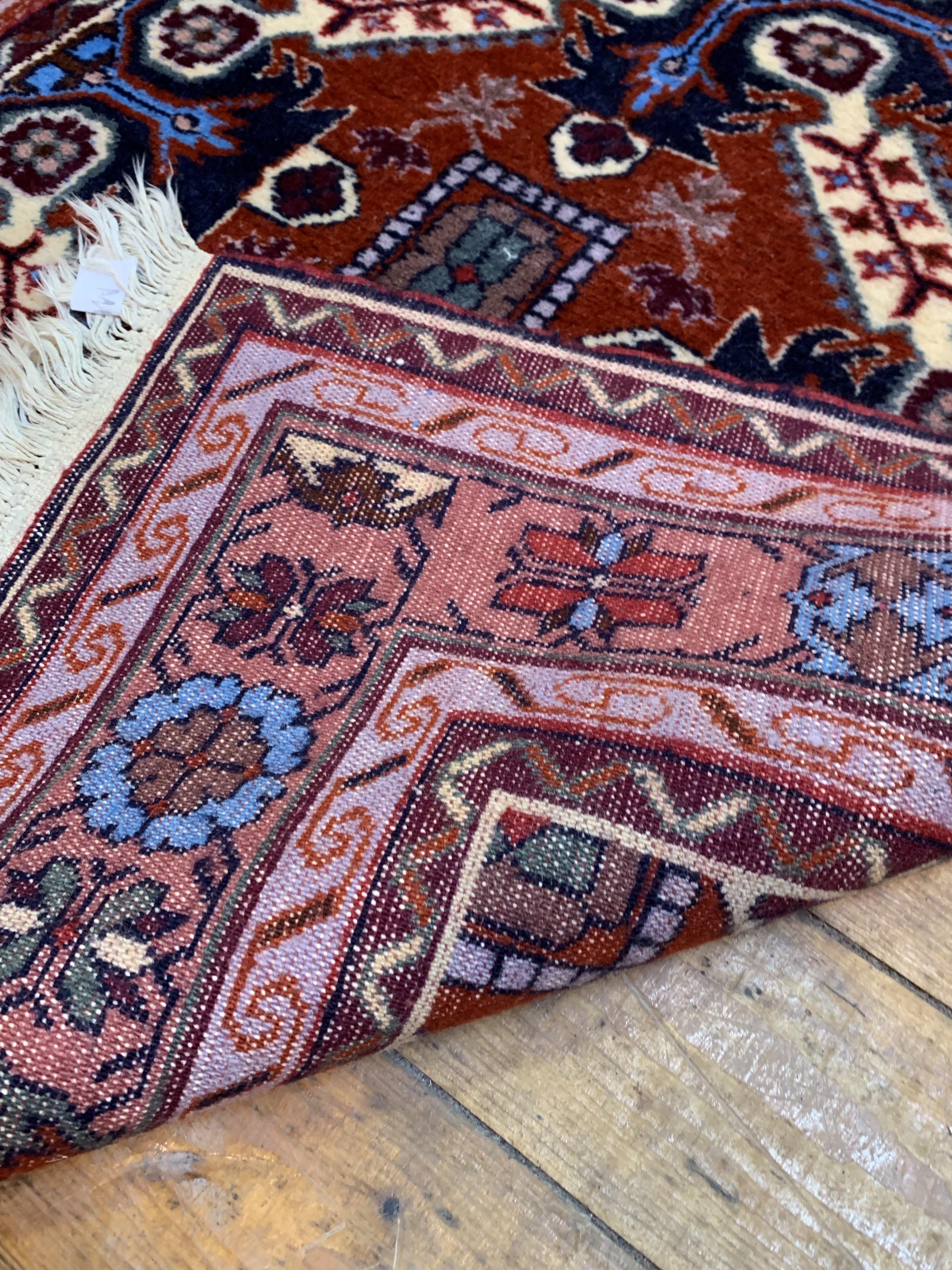 A hand knotted North West Persian rug, the madder ground of repeating design enclosed by double - Image 3 of 3