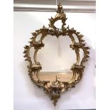 A George III carved giltwood and gesso wall mirror, the frame with 'C' scrolls, acanthus leaf,