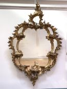 A George III carved giltwood and gesso wall mirror, the frame with 'C' scrolls, acanthus leaf,