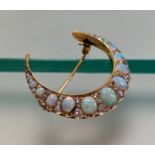 A late 19th century opal and diamond crescent brooch, set with nine oval-cut graduated opals