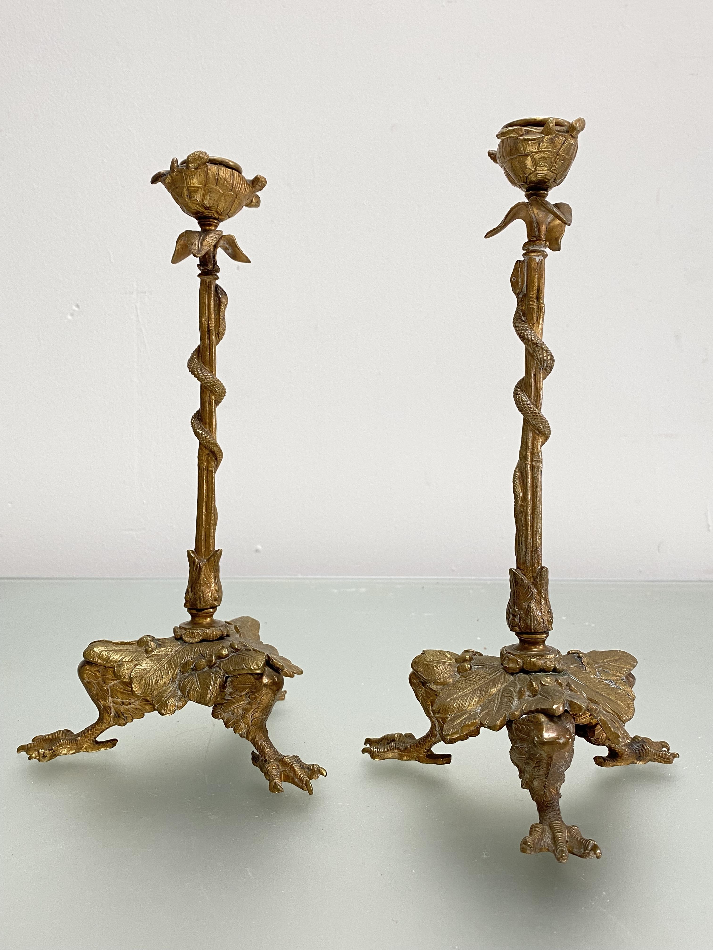 A pair of gilt-bronze candlesticks in the Regency taste, each with tri-form base modelled as