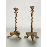 A pair of gilt-bronze candlesticks in the Regency taste, each with tri-form base modelled as