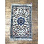 A small Iranian hand knotted rug, the cream field with blue medallion and interlaced trailing