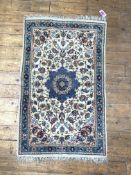 A small Iranian hand knotted rug, the cream field with blue medallion and interlaced trailing