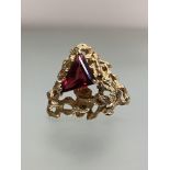A vintage 9ct gold brooch set to the centre with a triangular-cut garnet, on an open textured