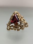 A vintage 9ct gold brooch set to the centre with a triangular-cut garnet, on an open textured