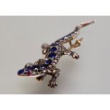 A diamond-set novelty brooch modelled as a lizard, the body further set with a line of graduated