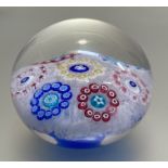 A dated Baccarat latticino-ground patterned millefiori paperweight, set with yellow, blue, red
