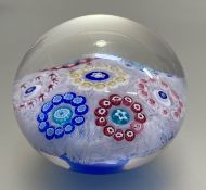 A dated Baccarat latticino-ground patterned millefiori paperweight, set with yellow, blue, red