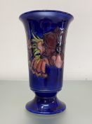A large Moorcroft Pottery vase, of tapering cylindrical form, with everted rim and raised on a