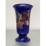 A large Moorcroft Pottery vase, of tapering cylindrical form, with everted rim and raised on a