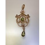 An Edwardian 15ct gold peridot and seed pearl pendant, the pear-cut and round-cut peridots each