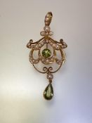 An Edwardian 15ct gold peridot and seed pearl pendant, the pear-cut and round-cut peridots each