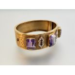 A late 19th century amethyst and seed pearl set hinged cuff bangle, the three large graduated