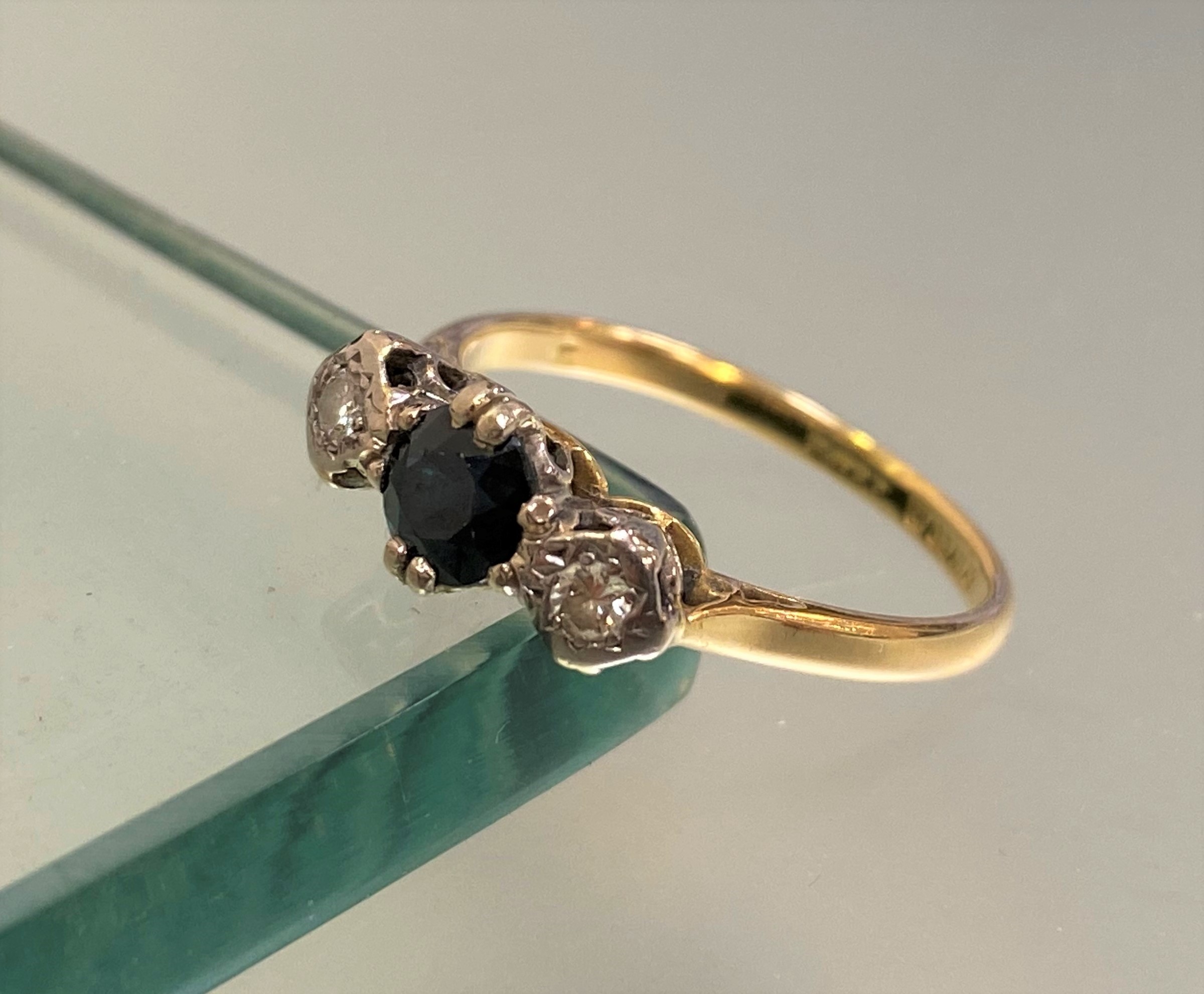An 18ct gold three stone sapphire and diamond ring, the central round-cut sapphire claw-set - Image 2 of 3