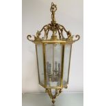 A large gilt-brass hall lantern, the tapering hexagonal frame inset with six bevelled glass panels