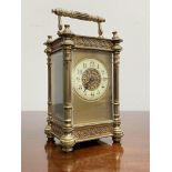 A late 19th century brass carriage clock, the four-glass case with fluted columns and cast with