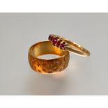 An 18ct gold wedding band, engraved with a pattern of stars; together with a five stone garnet ring,