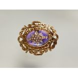 A 9ct gold amethyst glass and seed pearl brooch, the central oval cabochon mounted with a seed-pearl