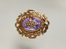 A 9ct gold amethyst glass and seed pearl brooch, the central oval cabochon mounted with a seed-pearl