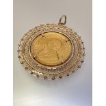 South Africa: a Krugerrand, 1975, mounted as a pendant in a pierced frame, the bale stamped 9k.