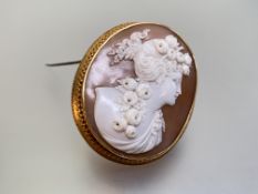 A large yellow-metal mounted shell cameo brooch, c. 1900, carved as a bust of a Classical lady
