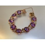 An amethyst bracelet, the eight uniform round-cut stones claw-set in conforming yellow metal discs