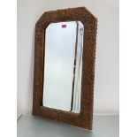 A stamped leather wall mirror in the Arts & Crafts taste, the frame decorated with a Celtic Knot