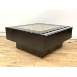 A contemporary coffee table of square form, the plate glass top enclosing colour changing fibre