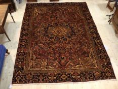 A Persian Hariz rug the central medallion on scrolling vine and flower field with spandrels to