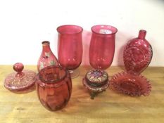 A collection of cranberry glass including two tulip shaped footed vases, measuring 21cm high, a