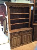 A late 19thc pine dresser the projecting dentil cornice over three height plate rack with two