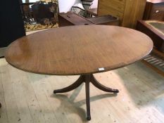 A Bevan Funnel Reprodux Regency style mahogany oval pedestal table the cross bonded top raised on