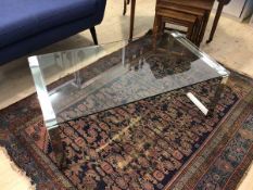A contemporary coffee table the glass top on open square polished metal supports, measures 38cm x