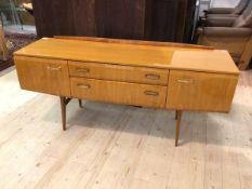 A mid century sideboard / dressing table with ledgeback over two drawers and two cupboards raised on