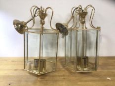 A pair of modern brass and glass hexagonal hall lanterns with bevelled glass panels and three lamp
