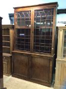 A George III mahogany bookcase on cupboard, the projecting cornice over two Gothic arched tracery